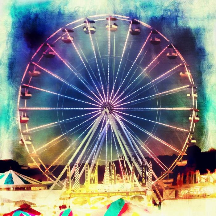 A woman rides a carnival ferris wheel